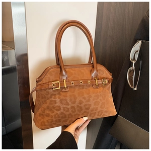 Detail of leopard print tote bag with gold metal eyelets and dual round handles