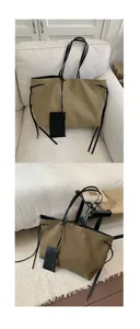 Detail view of canvas tote bag with side ties and detachable small black zip pouch
