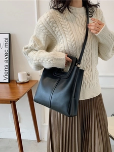 Chic black large capacity bucket tote bag with cutout handles and adjustable shoulder strap