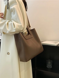 Large dark brown leather tote bucket bag with cutout handles and shoulder strap