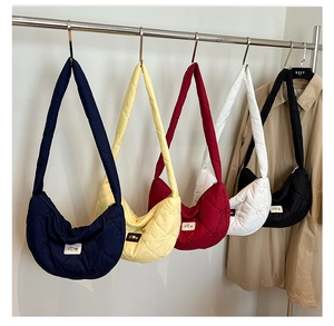 Close-up of quilted crescent shoulder bags in five colors with heart pattern stitching