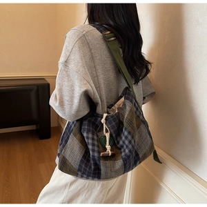 Détail du sac à carreaux rétro avec pendentif en cœur vert et cordon de serrage