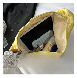 Spacious interior of yellow quilted tote bag showing tablet and cosmetic storage
