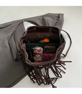 Top view of spacious dark brown fringe bucket bag showing storage for umbrella and phone