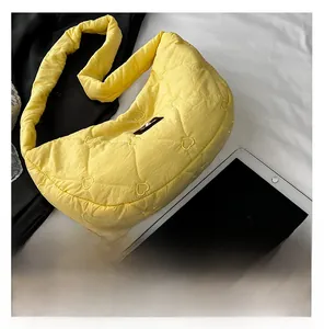 Detail showing yellow quilted cloud bag with heart embroidery and black woven label