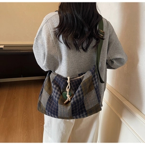 Détail du sac vintage à carreaux en toile avec boucle en corne et sangle olive