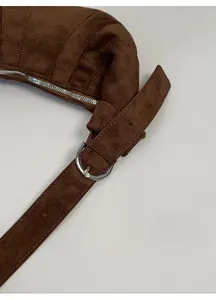 Detail of adjustable strap buckle and zipper on brown suede croissant bag