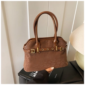 Close-up of brown leopard print tote bag with suede texture and gold metal eyelet details