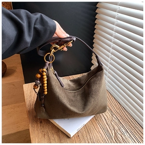Detail of suede crossbody bag featuring retro wooden beads and vintage gold buckle