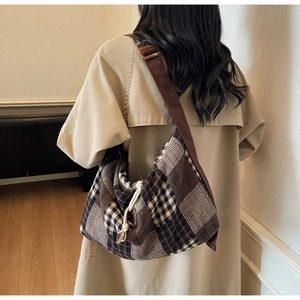 Detail of a large checkered wool tote bag with a brown wide shoulder strap for autumn