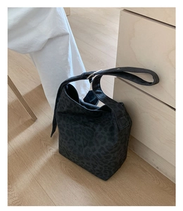 Detail of black leopard print canvas tote with adjustable strap and silver buckle