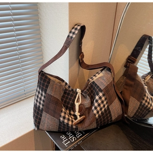 Detailed view of the plaid tote bag featuring a vintage toggle clasp and woven wool texture