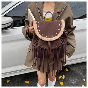 Detailed view of vintage brown suede backpack with silver star rivets and long fringes