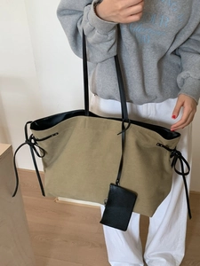 Vintage khaki canvas tote bag with black shoulder straps and a small detachable pouch