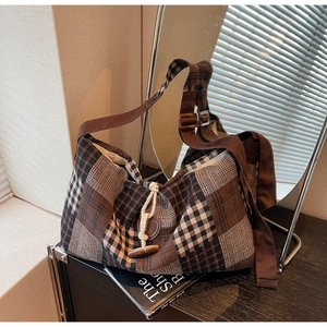 Gros plan d'un sac cabas vintage à carreaux avec bouton en corne et texture tissée