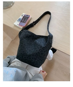 Detail of black leopard jacquard bucket bag with adjustable strap in a lifestyle setting