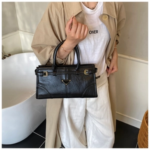 Classic black leather handbag styled with a khaki trench coat for a chic daily look