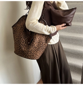 Detail view of large leopard print faux suede tote bag set with brown leather handle