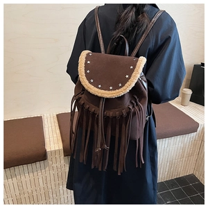 Detail of bohemian brown suede backpack with star rivets and fringe on the front pocket