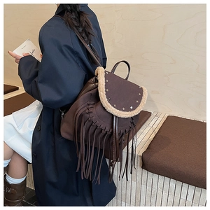 Close-up of brown vintage fringe backpack with metal studs and faux fur trim detail