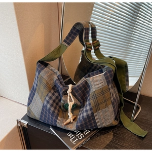 Vue détaillée du sac hobo à carreaux vintage avec bouton en bois et bandoulière verte