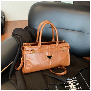 Detailed close-up of brown PU leather bag with vintage texture and gold buckle accents