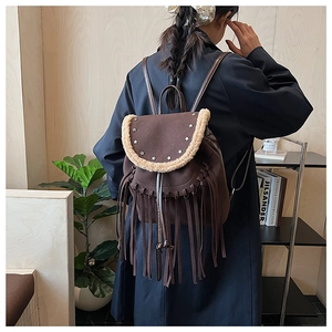 Detail of dark brown fringe backpack with star rivets and plush trim on the flap