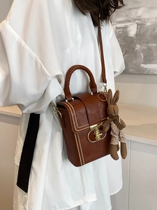 Vintage brown square shoulder bag with metal studs and a cute plush rabbit charm