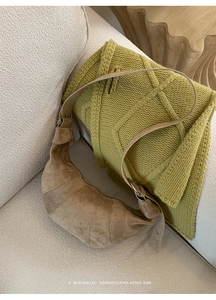 Detailed texture of brown suede croissant bag showing quilted sections on white sofa