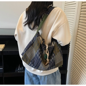 Détail du grand sac cabas à carreaux avec cordon décoratif et breloque ronde verte