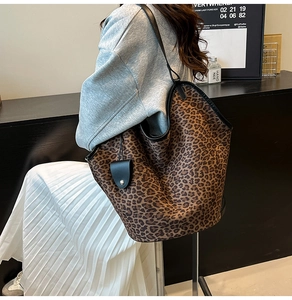 Macro shot of large leopard print tote bag with black leather straps and side charm