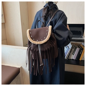 Detail of dark brown fringe backpack with silver star rivets and plush trim on cover