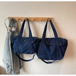 Detail showing two sizes of navy blue denim tote bags with adjustable crossbody straps
