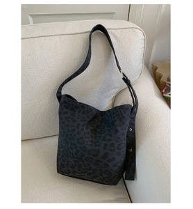 Detail of grey leopard print canvas tote with wide adjustable strap on white sofa
