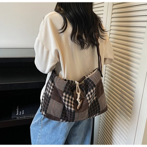 Détail d'un grand sac cabas à carreaux avec cordelette et bouton en bois