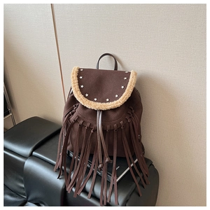 Detail of dark brown fringe backpack with star studs and plush trim on leather seat