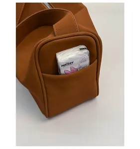 Detailansicht der praktischen Seitentasche an einer braunen matten Wildledertasche