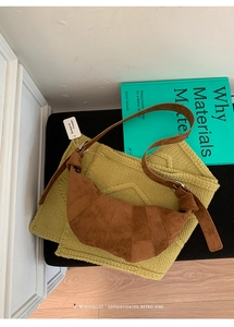 Detail of a brown suede croissant bag with layered stitching and wide knotted strap