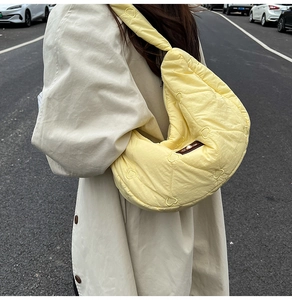 Detail of a light yellow cloud bag with heart-shaped quilting and pearl button decor