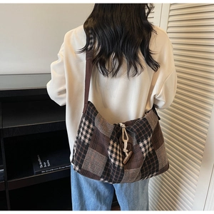 Détail du sac hobo avec motif patchwork à carreaux et fermeture bouton à bascule
