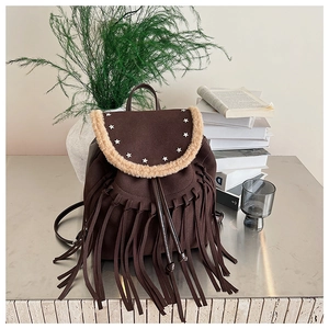 Detail of brown bohemian suede backpack with fringe tassels and star metal rivets