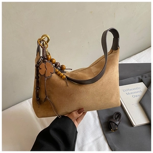 Detail of brown suede hobo bag with bohemian bead charm and adjustable strap