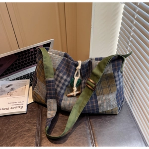 Détail du sac cabas vintage à carreaux avec bandoulière verte et boucle en corne