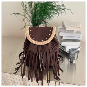 Detail of bohemian dark brown fringe backpack with faux fur trim and star rivets