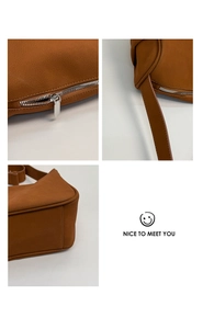 Details der karamellfarbenen Zylindertasche mit Silberreißverschluss und Gurt