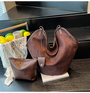 Detail of dark brown suede tote bag and matching leather pouch on a wooden step