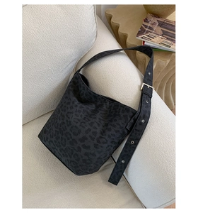 Detail of black leopard print hobo bag texture with adjustable wide strap in home setting