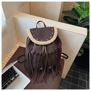 Detailed shot of vintage brown backpack with fringe tassels and star rivet ornaments