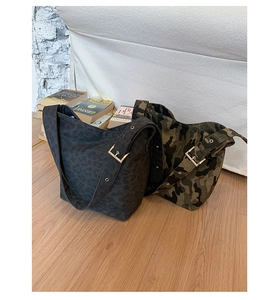 Detail of camouflage and leopard print tote bags with adjustable metal buckle straps