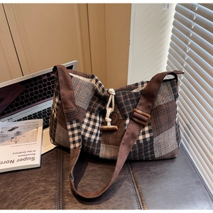Détail d'un sac bandoulière vintage à carreaux avec fermeture à bouton bascule en bois